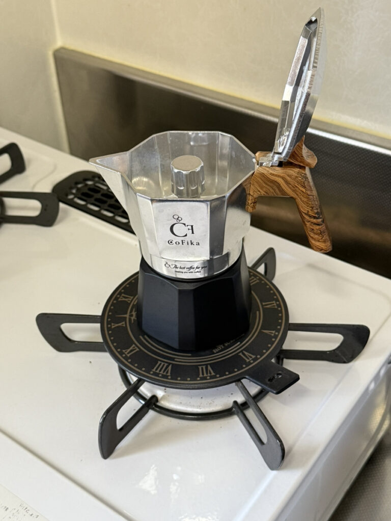 ガスコンロでCoFika Crema Richを使用中。ヒーティングプレート（BLACK CHRONO）を五徳に乗せて加熱している様子。